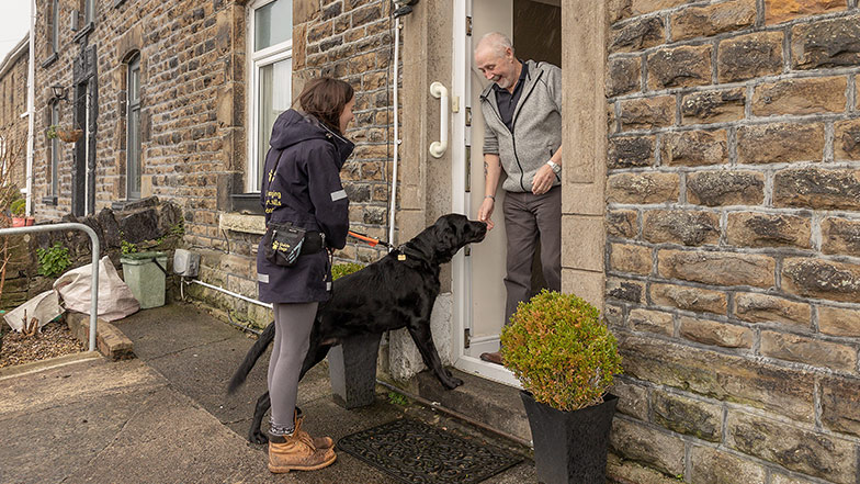 A member of staff introducing a man with a VI to a guide dog