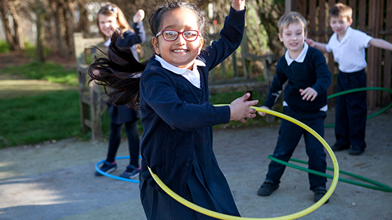 Children playing with hula hoops in school playground