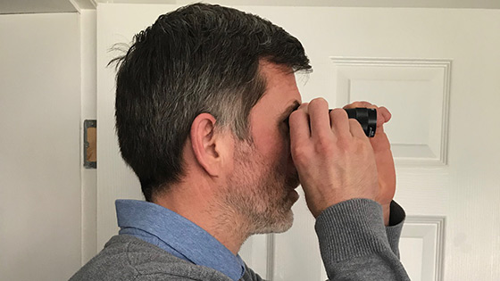 Side view of a man using a monocular