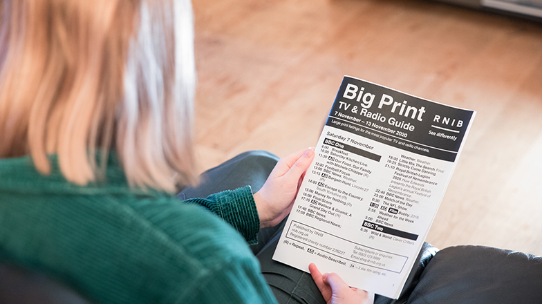 Woman reading a big print TV guide