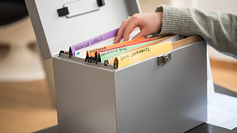 Person using filing system with colourful dividers for important documents