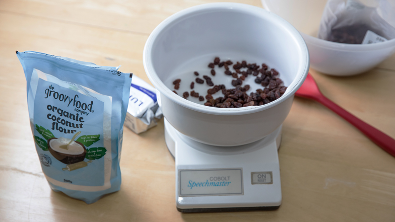 A talking kitchen scale with raisins in the measuring bowl
