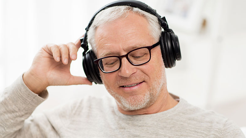 A man smiling and enjoying listening to an audiobook on audible