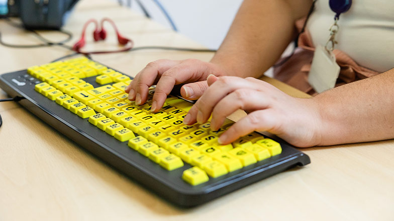 A woman using a large print keyboard 