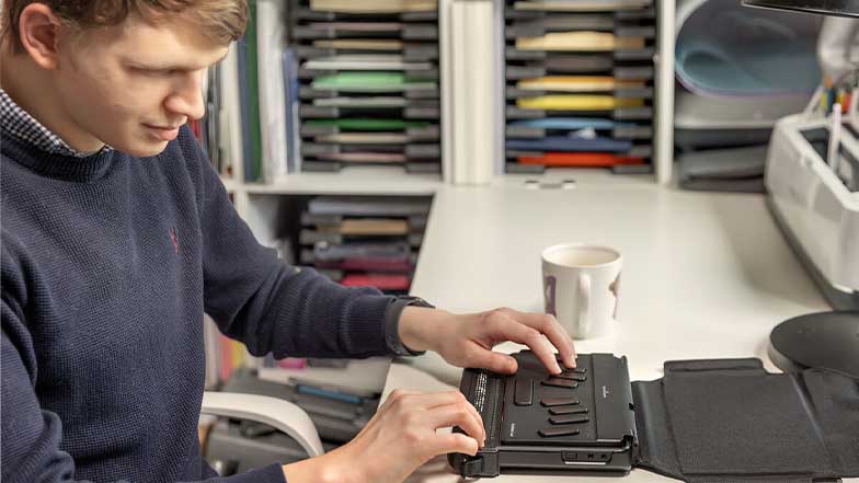 A man working on a braille keyboard