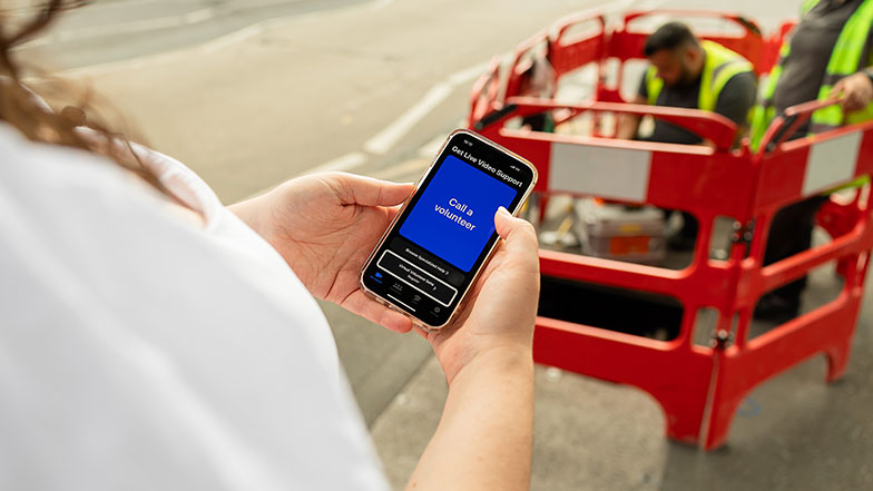 An image of a Vision impaired user using the Be My Eyes app on her phone to guide her.