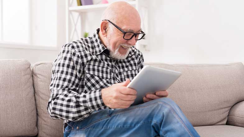 An image of an older man using the RNIB reading services on his tablet.