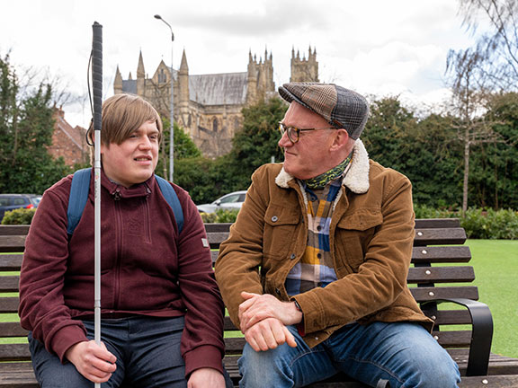 Lewis (left) and Andrew (right) on a bench in front of Beverley Minster