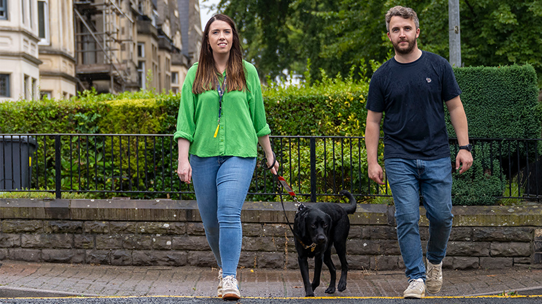 Volunteer fosterers cross the street with a guide dog 