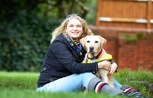 Volunteer Anica hugs her guide dog